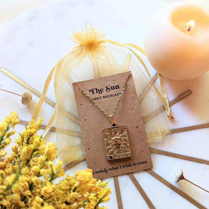 Tarot Sun Necklace hanging on the packing it comes in