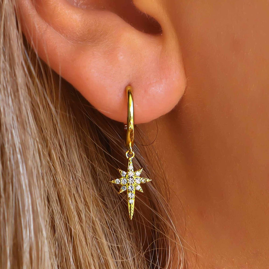 Gold Crystal Star Earrings on a model close up