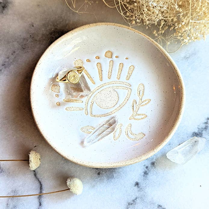 Evil Eye Adjustable Gold Ring on a ring dish