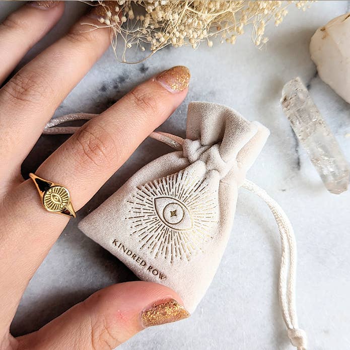 Evil Eye Adjustable Gold Ring being worn with a velvet bag