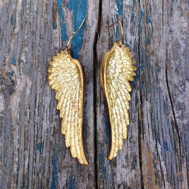 Golden Wing earrings laying down 