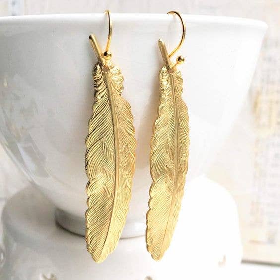 Feather earrings hanging on cup