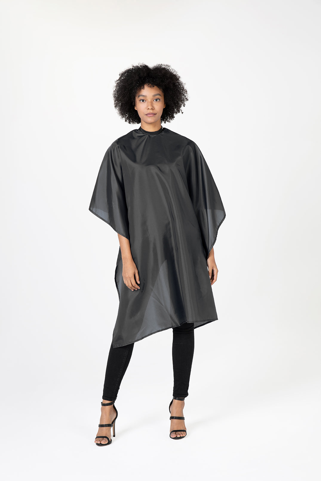 Woman wearing a black hairdressing cape against a white background