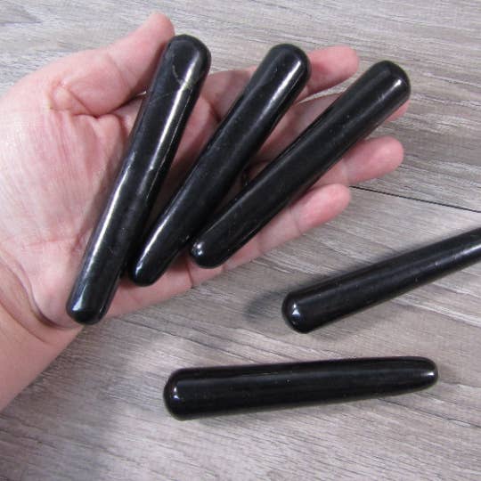 Shungite Wands in hand and on table