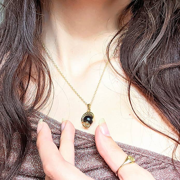 The Crystal Ball Necklace on a woman's neck to show sizing 