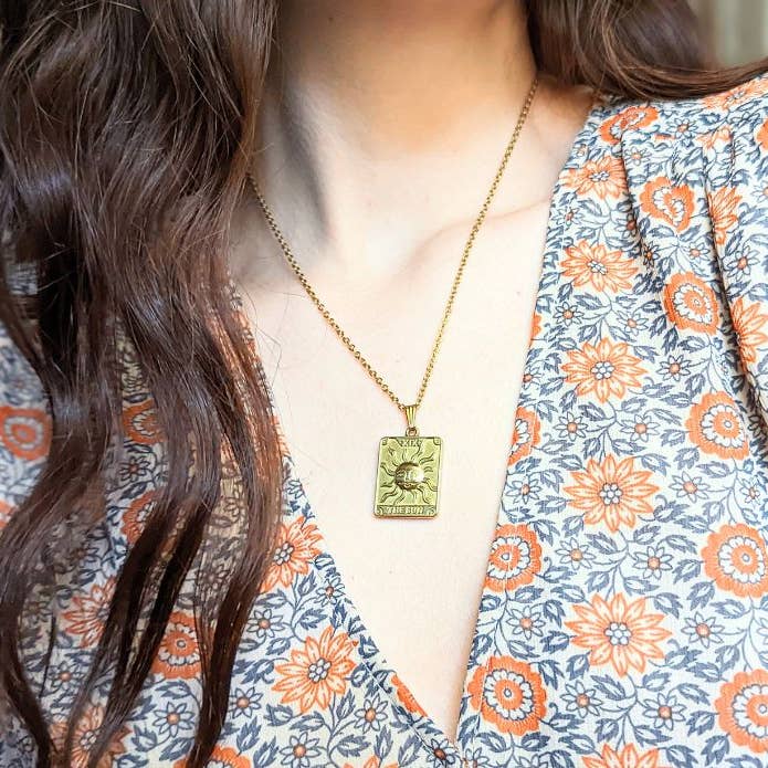 Tarot Sun Necklace hanging on a woman's neck to show its length