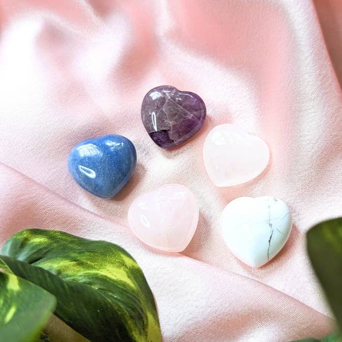 The five crystals included in the Crystal Heart Tin Set with amethyst, quartz, rose quartz, howlite, and blue aventurine.