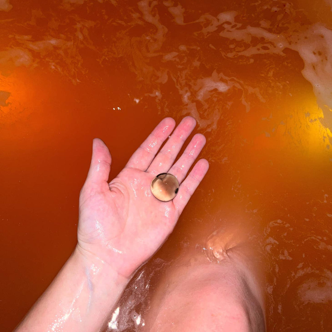 A picture of the bath bomb dissolved with a smoky quartz inside. 