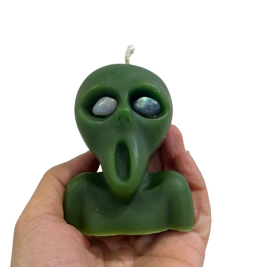 Someone holding a Green Alien Candle with Crystal Eyes