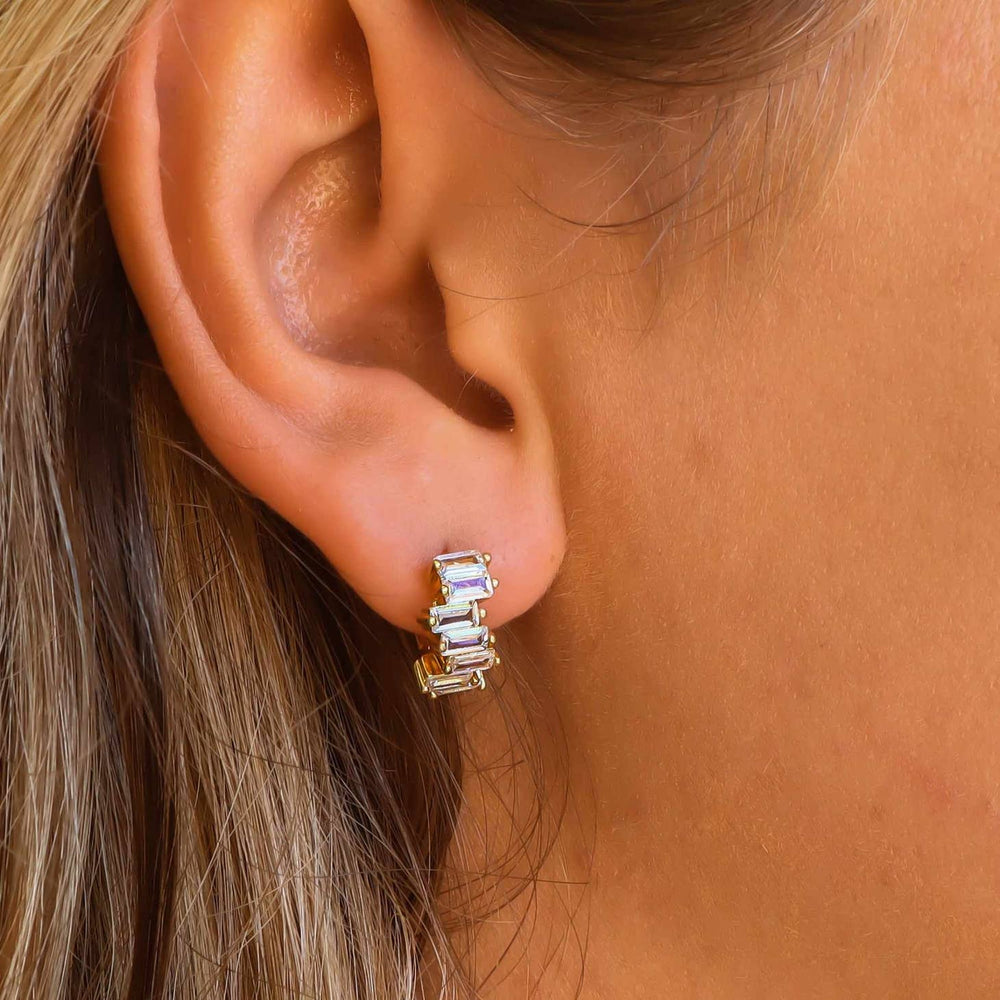 Crystal Huggie Hoops on a woman's ear for reference