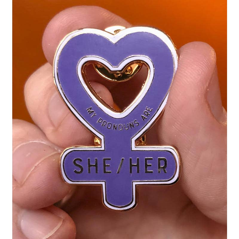 Someone holding the My Pronouns are She/Her Enamel Pin