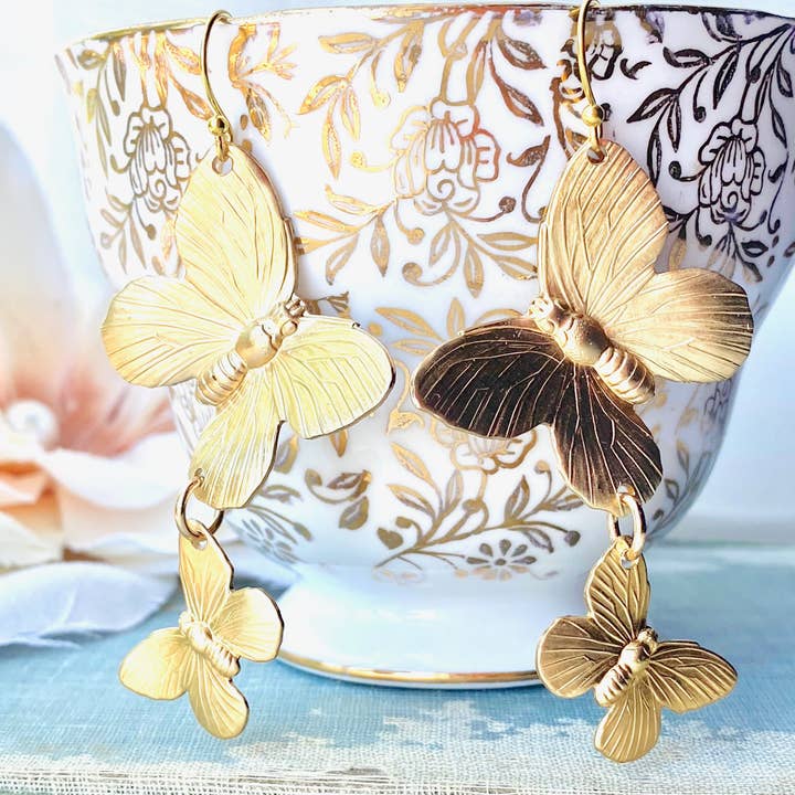 Butterfly earrings hanging on a cup