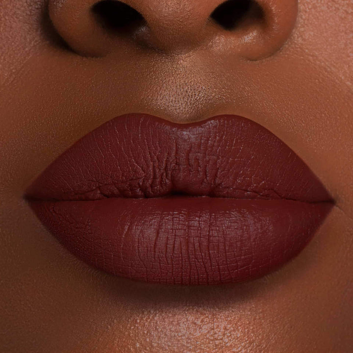 This is a dark skin tone lip swatch of the Brick Liquid Matte Lip.