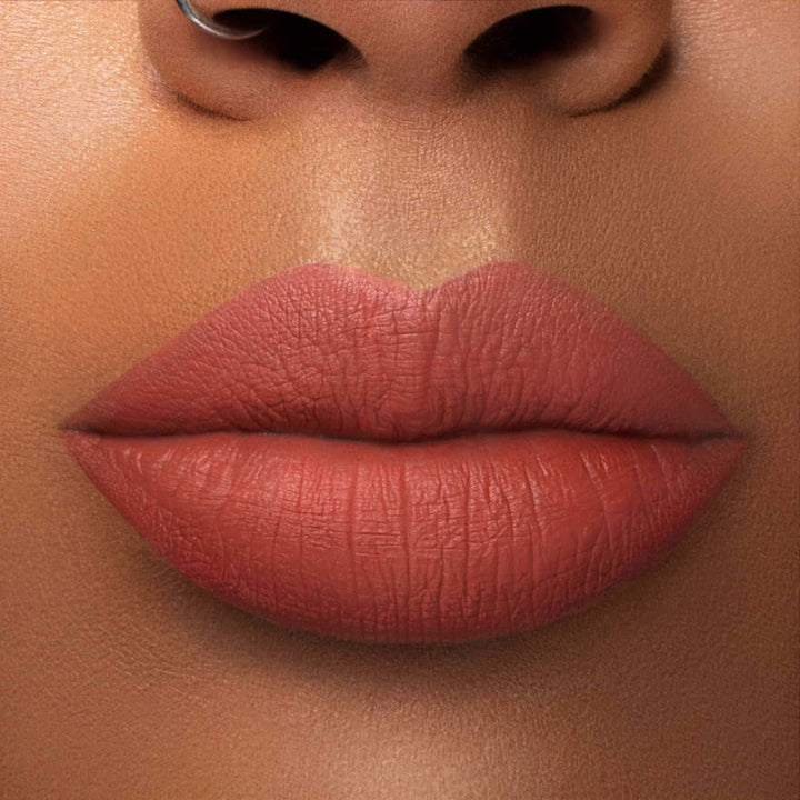 This is a medium skin tone lip swatch of the Campfire Liquid Matte Lip.