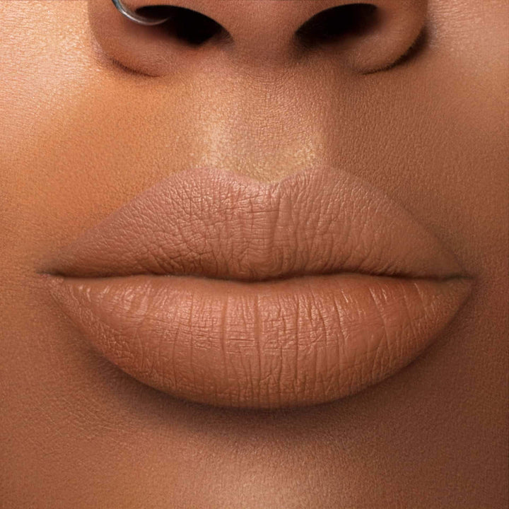 This is a medium skin tone lip swatch of the Knock on Wood Liquid Matte Lip.