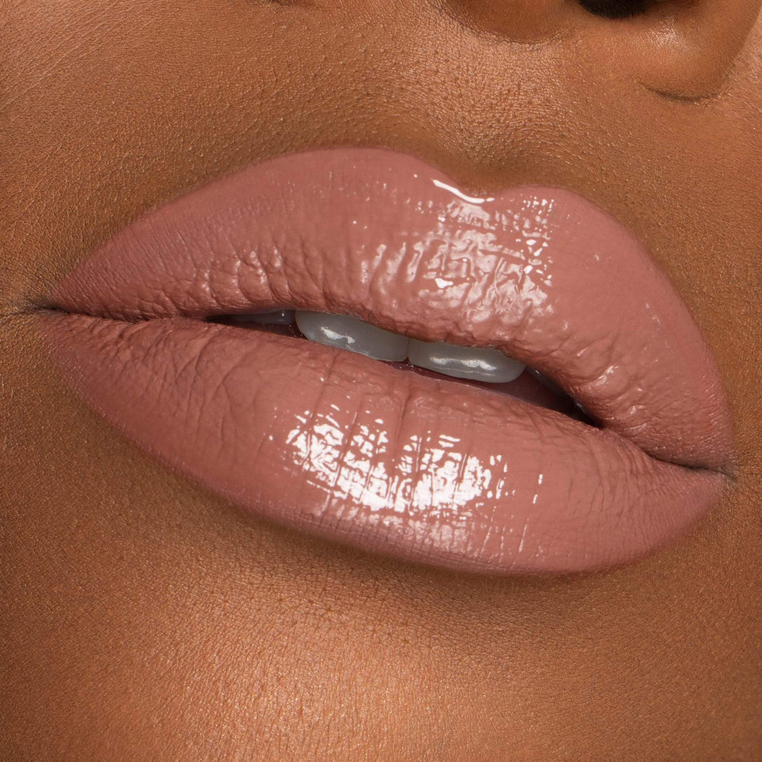 This is a model wearing the On Repeat Lip Gloss with a darker skin tone.