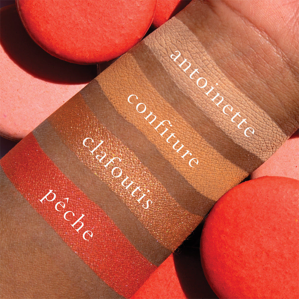 The Petits Fours Peche pallet swatched and labelled on a dark skinned person  