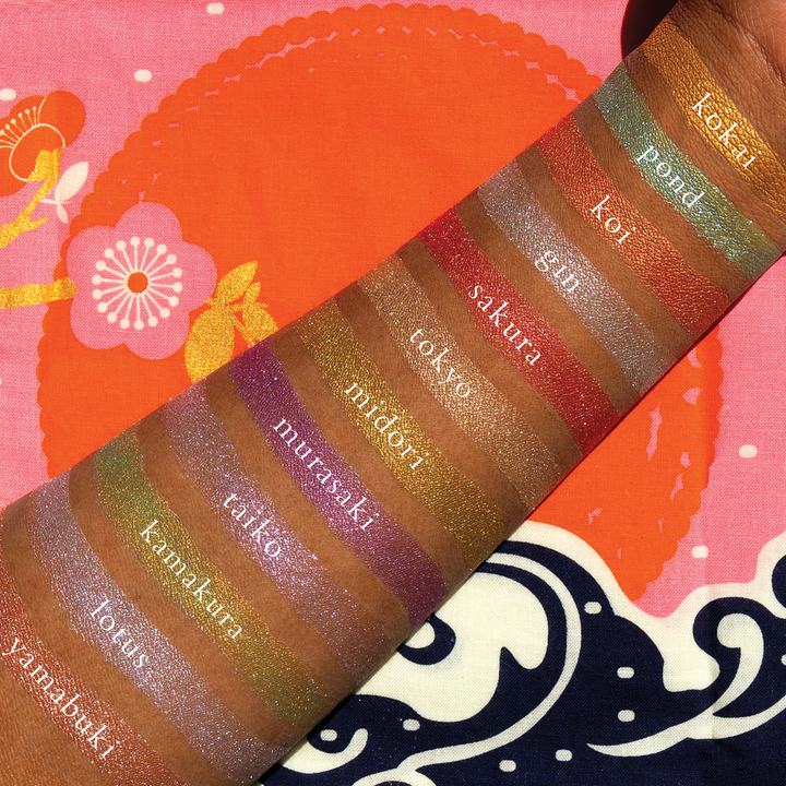 The Petites Shimmers Coy pallet swatched on a dark skinned person with each swatch labeled
