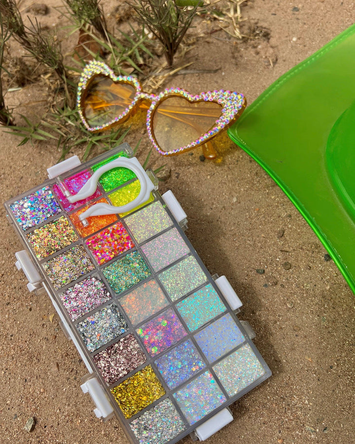 The back of the SpaceCase Pro-Palette Remix showing all of the glitters and the handle in the back. Beach or desert background with festival sunglasses. 