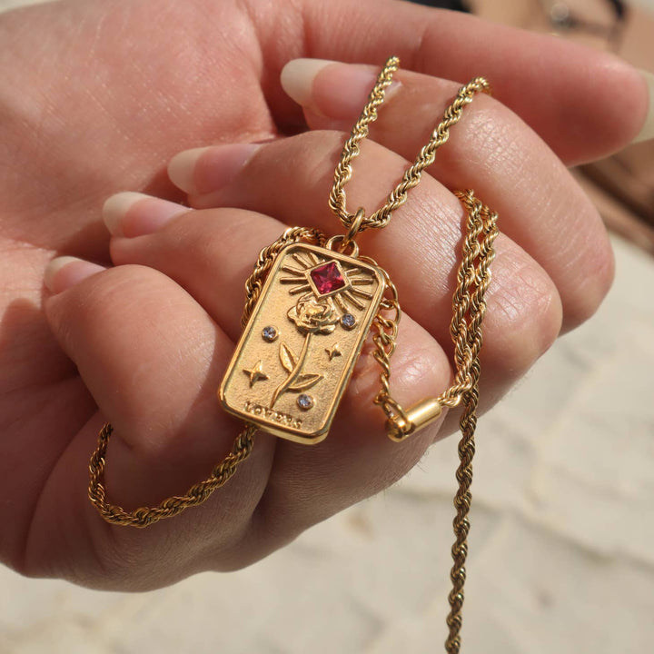 The Lovers' Tarot Card Necklace in a models hand