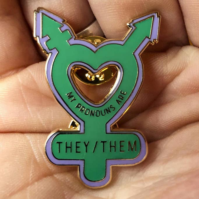 Someone holding the My Pronouns are They/Them Enamel Pin
