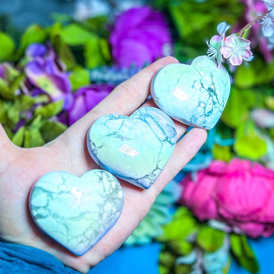 Multiple Aura Howlite stones in the palm of a hand