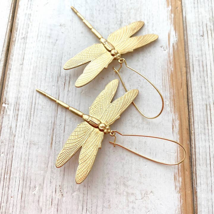 Dragonfly Earrings laying on wood