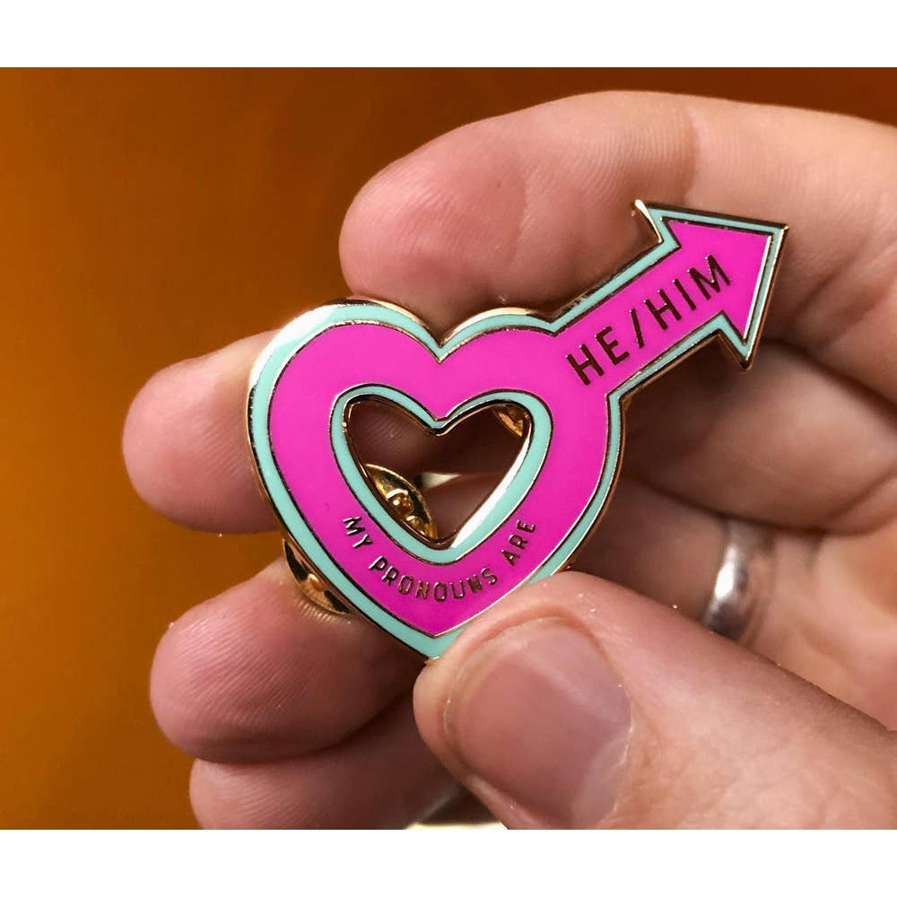 Someone holding the My Pronouns are He/Him Enamel Pin