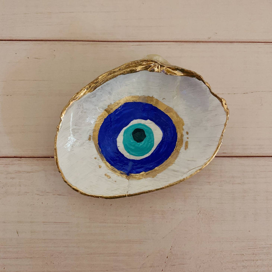 This is a hand painted shell with a white base and an evil eye in the center with gold on the edges.