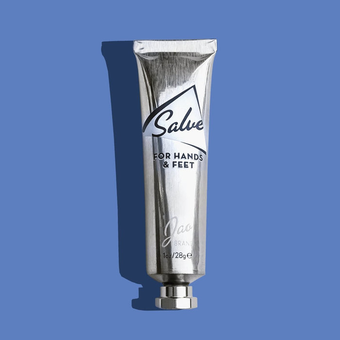 Silver tube of 'Salve for Hands & Feet' on a blue background