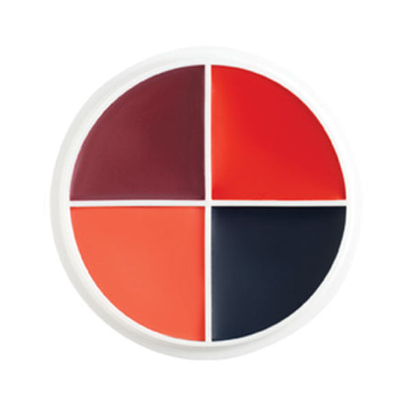 A circular four-color makeup palette with quarter-circle sections of deep burgundy, bright red, orange, and dark navy, surrounded by a white rim on a white background.