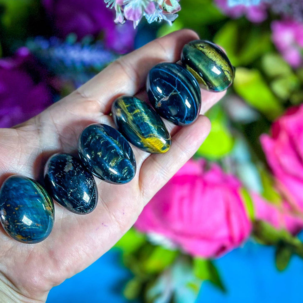 Blue Tigers Eye Tumblers close up in the palm of the hand 