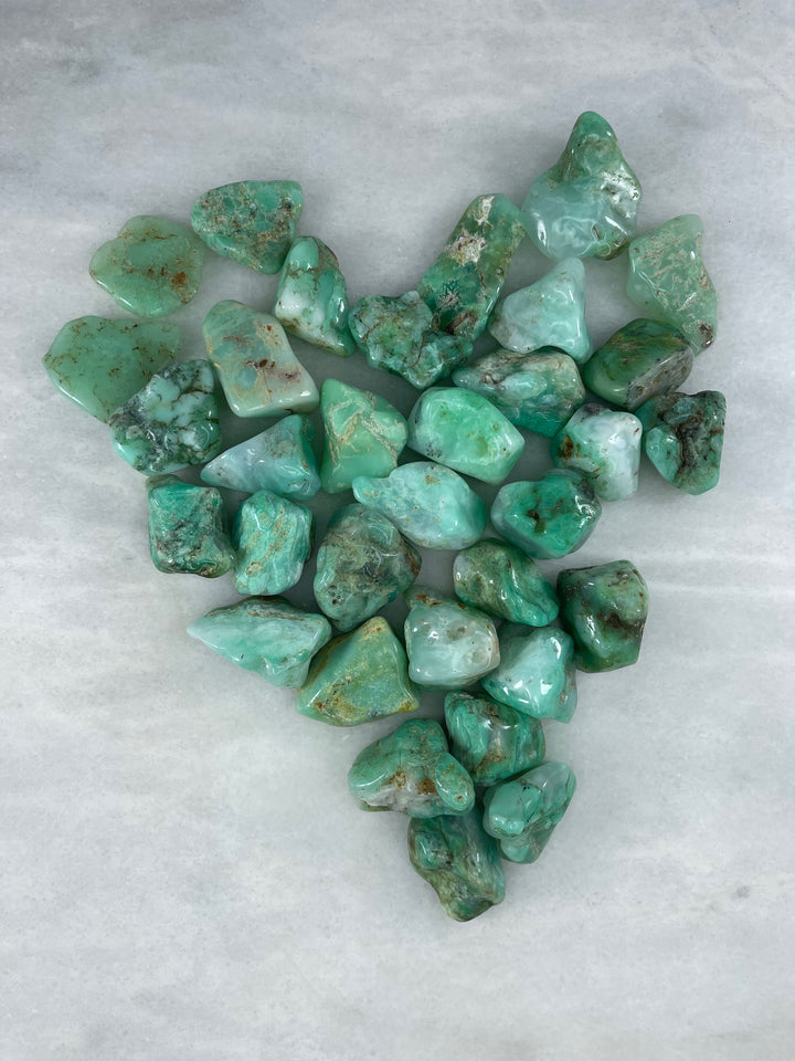Multiple Chrysoprase Raw Palm Stones in the shape of a heart paying an homage to its connection to the heart chakra