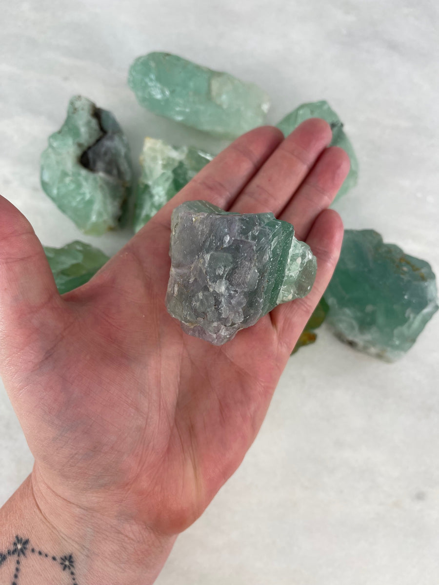 Raw Fluorite Palm Stone in the palm of the hand