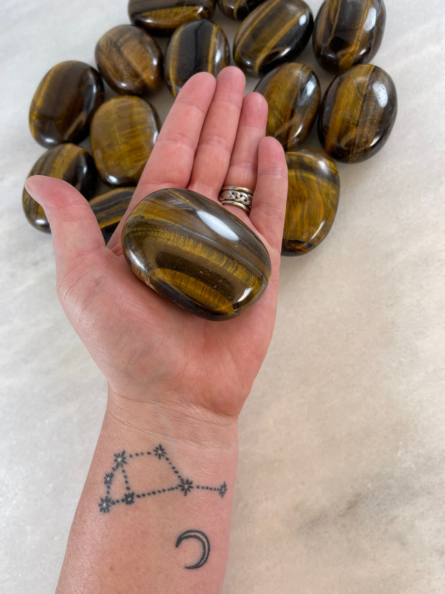 Tigers Eye Palm Stone in the palm of a hand